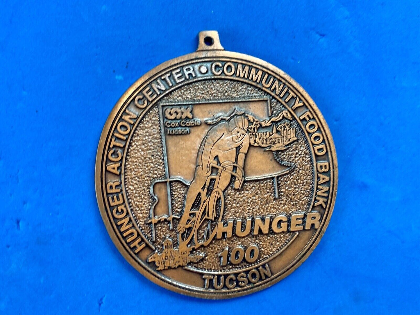 award round medal from El Tour De Tucson HUNGER Race