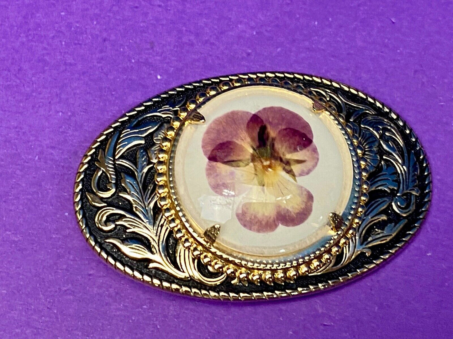 Beautiful pressed purple Violet flower as centerpiece in western belt buckle