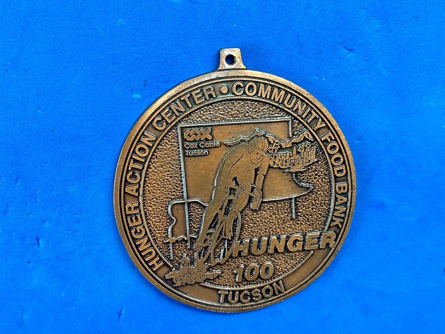 award round medal from El Tour De Tucson HUNGER Race