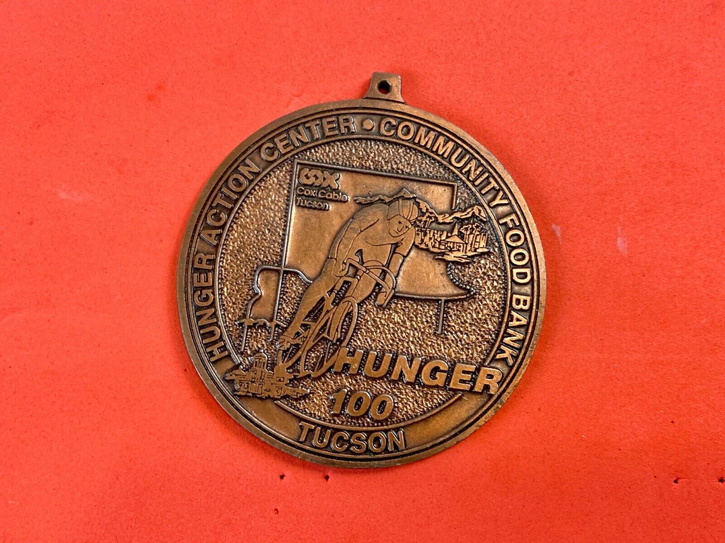 award round medal from El Tour De Tucson HUNGER Race