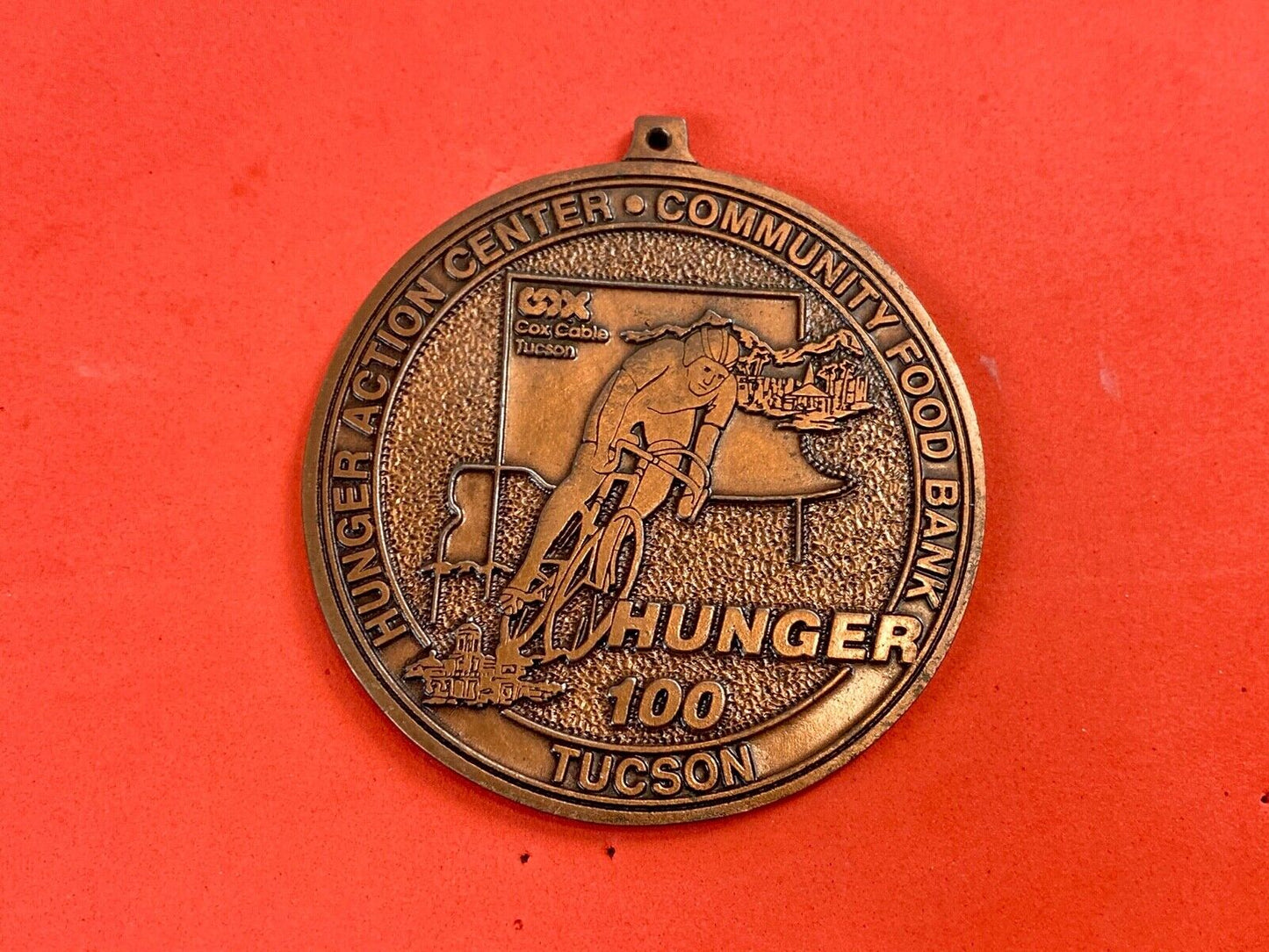 award round medal from El Tour De Tucson HUNGER Race