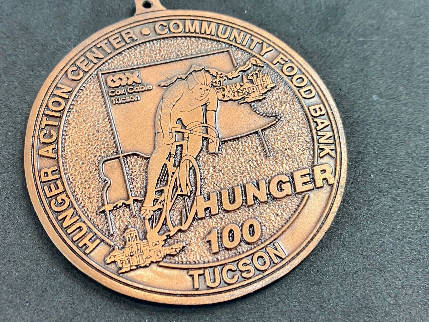 award round medal from El Tour De Tucson HUNGER Race