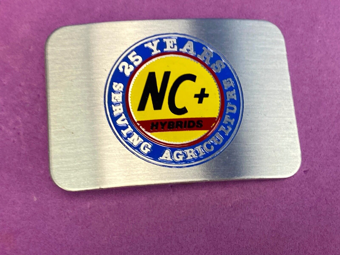25 years serving agriculture - NC+ Hybrids belt buckle