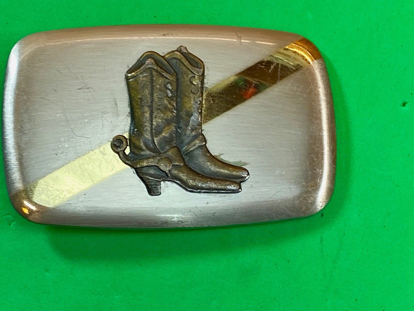 Vintage cowboy boots with spurs in center of mixed metal western belt buckle