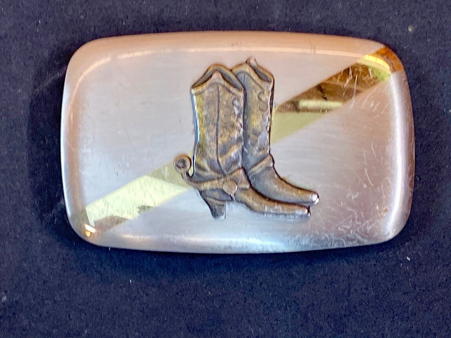 Vintage cowboy boots with spurs in center of mixed metal western belt buckle
