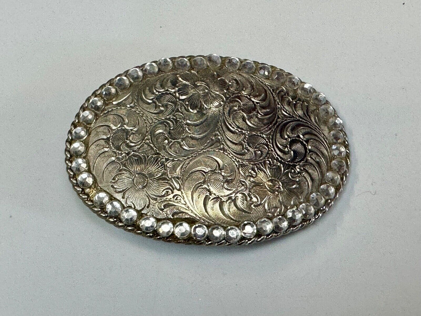 vintage 1996 western flower swirl oval belt buckle with rhinestone boarder