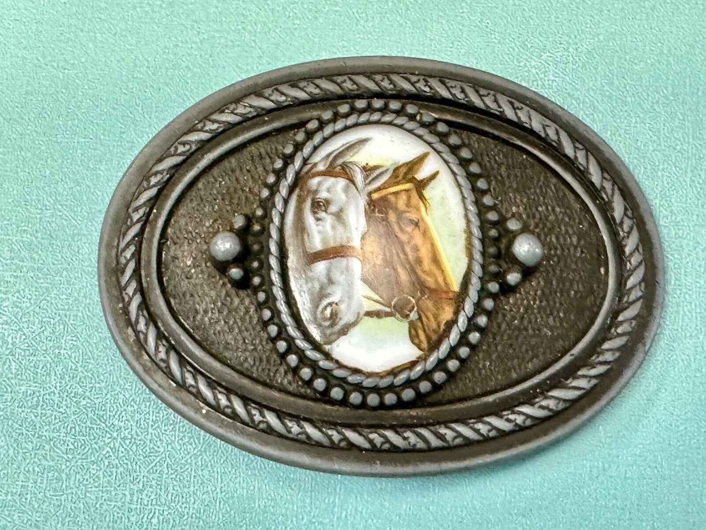 2 horses picture as centerpiece in western oval belt buckle with rope border