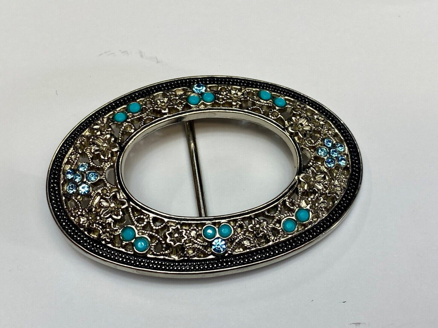Unique blue rhinestone accented oval see though silver tone belt buckle