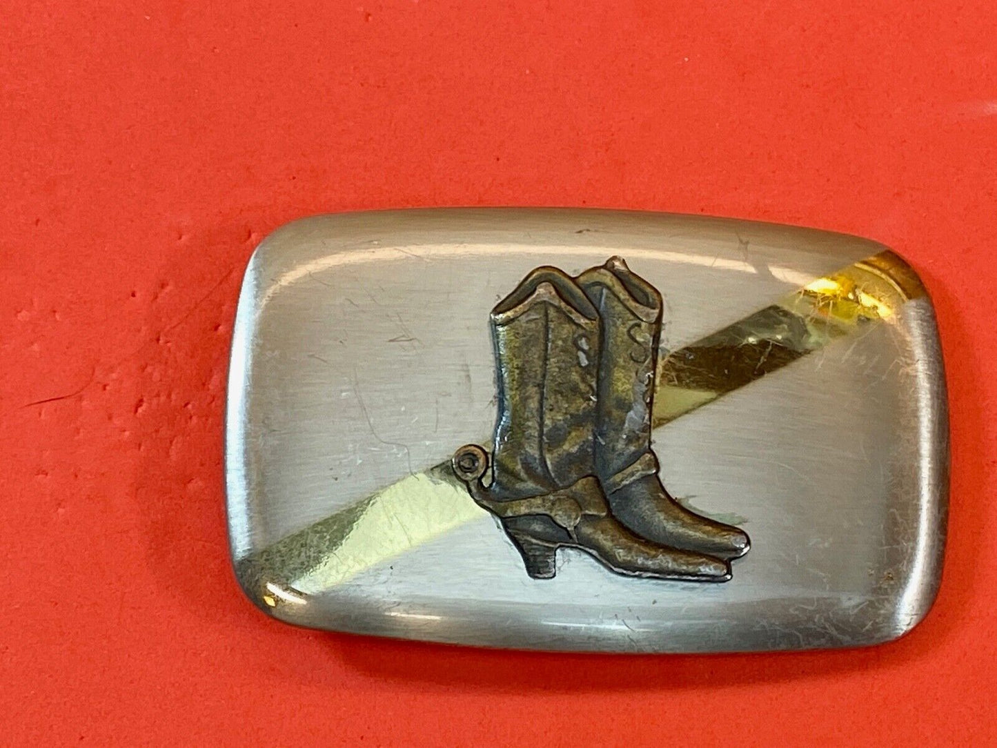 Vintage cowboy boots with spurs in center of mixed metal western belt buckle