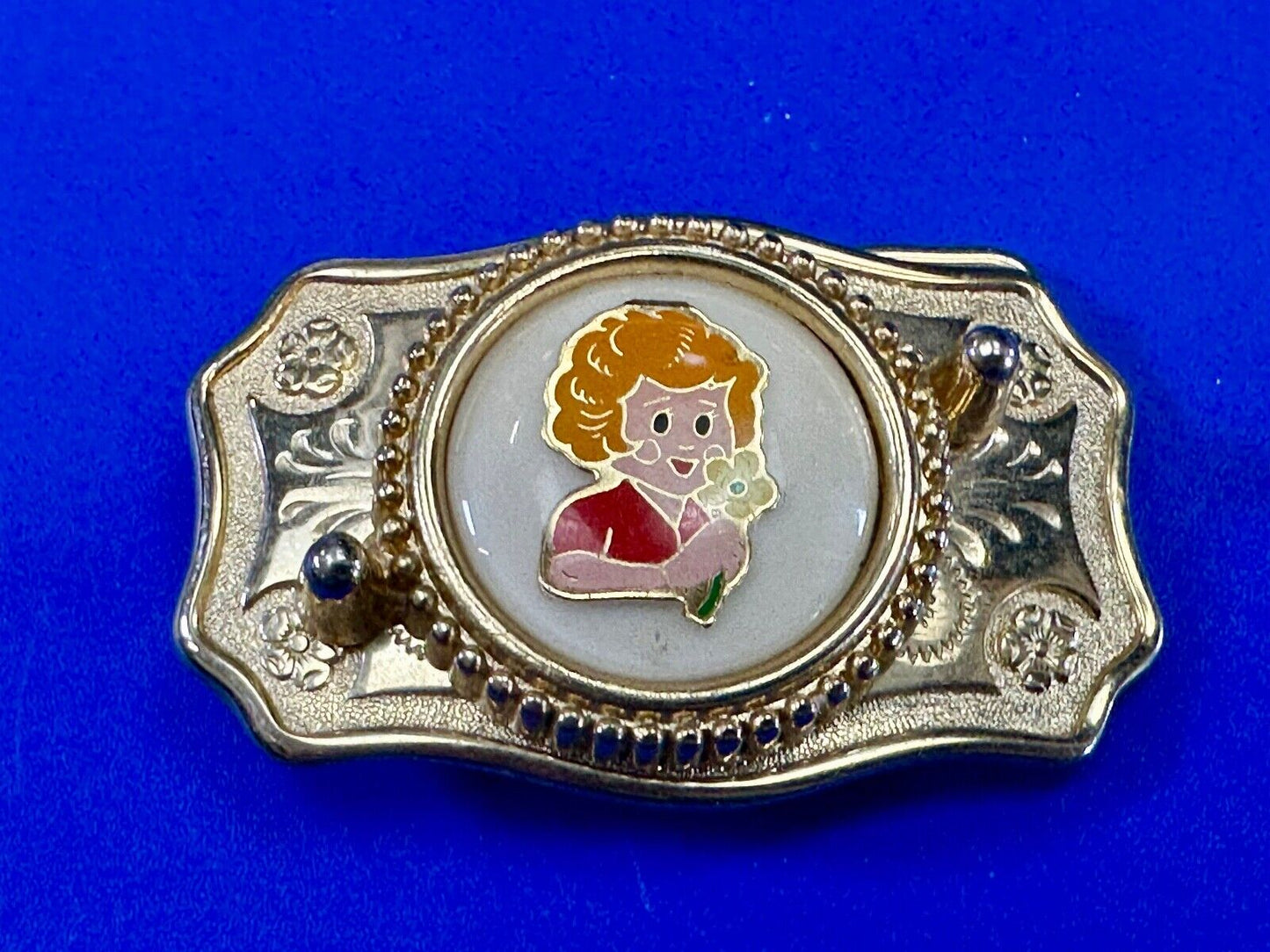 Adorable red headed girl with flower as centerpiece on western belt buckle