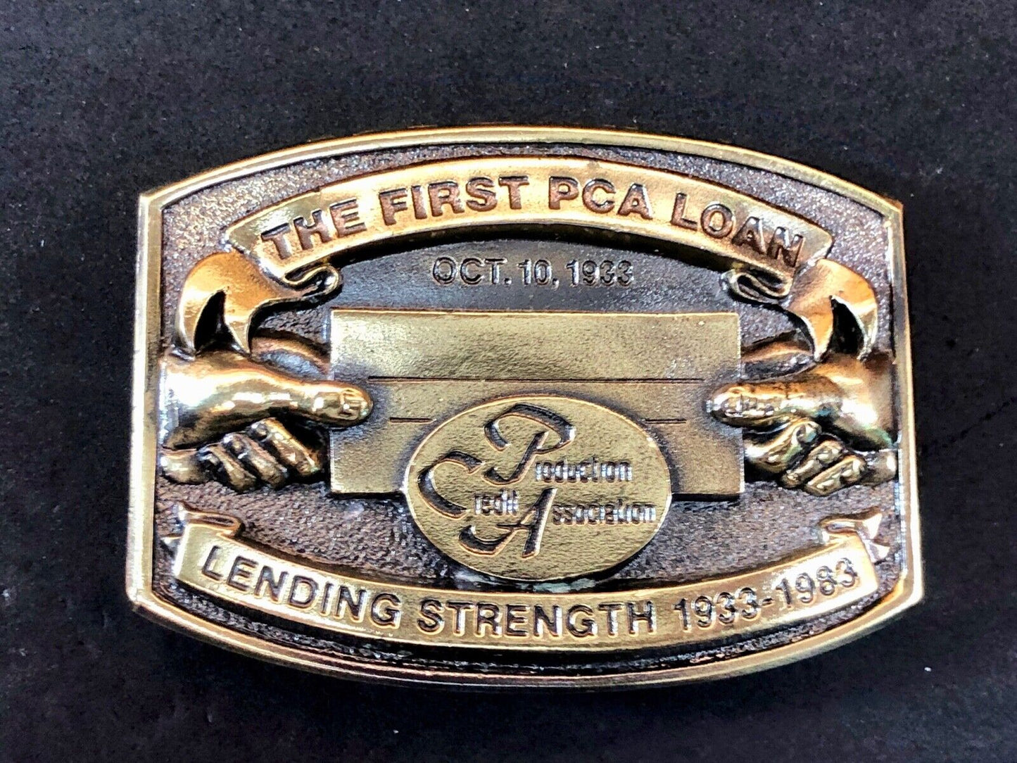 The first PCA loan belt buckle - Lending and strength production credit assn.