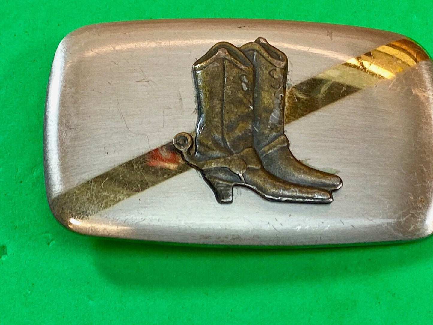 Vintage cowboy boots with spurs in center of mixed metal western belt buckle