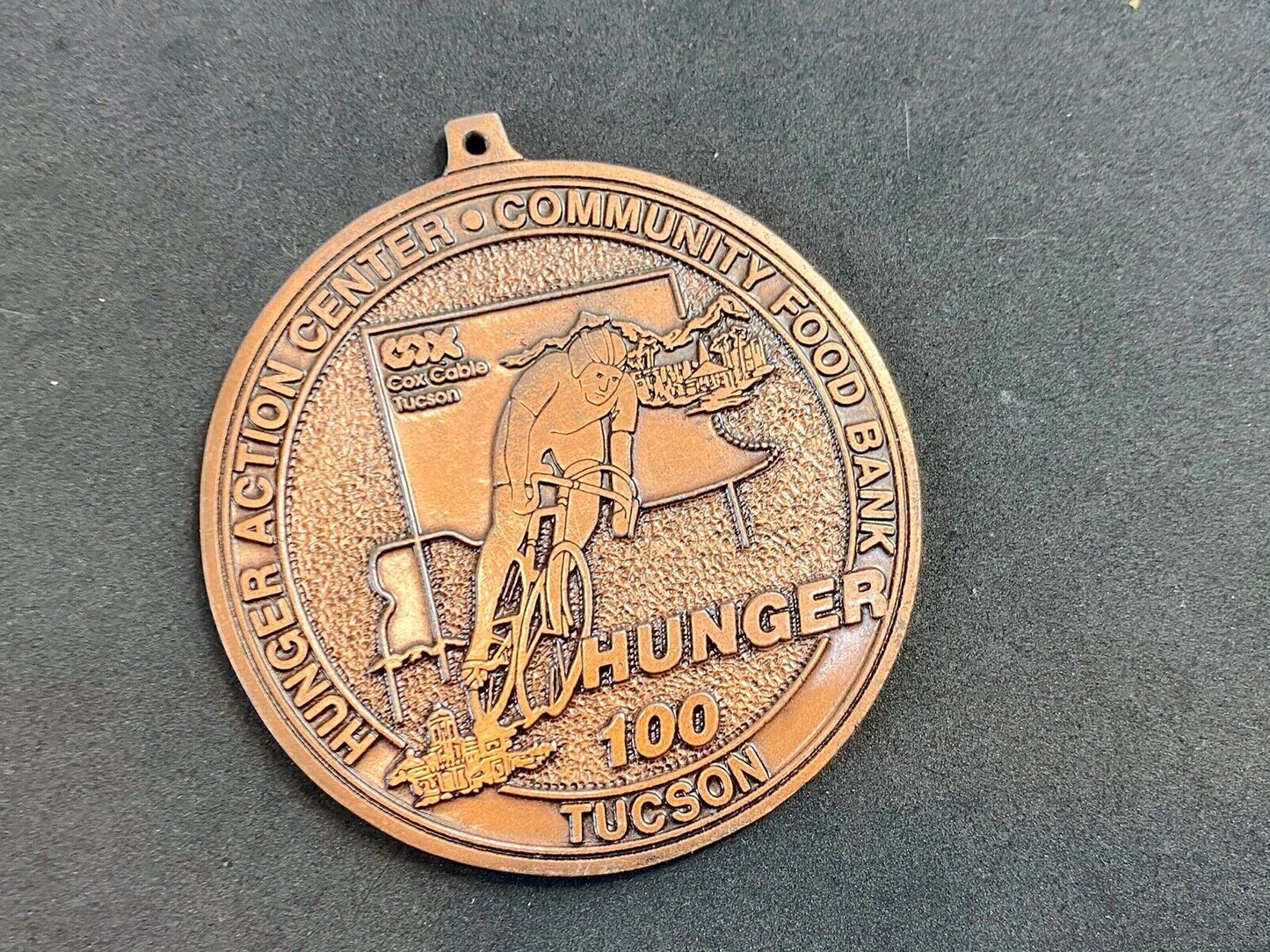 award round medal from El Tour De Tucson HUNGER Race