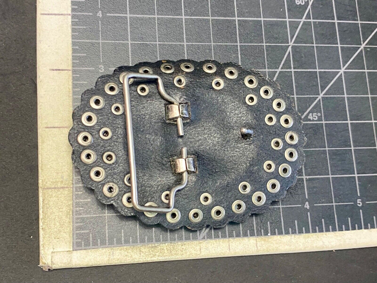 4" wide studded black leather oval belt buckle with flower swirl center