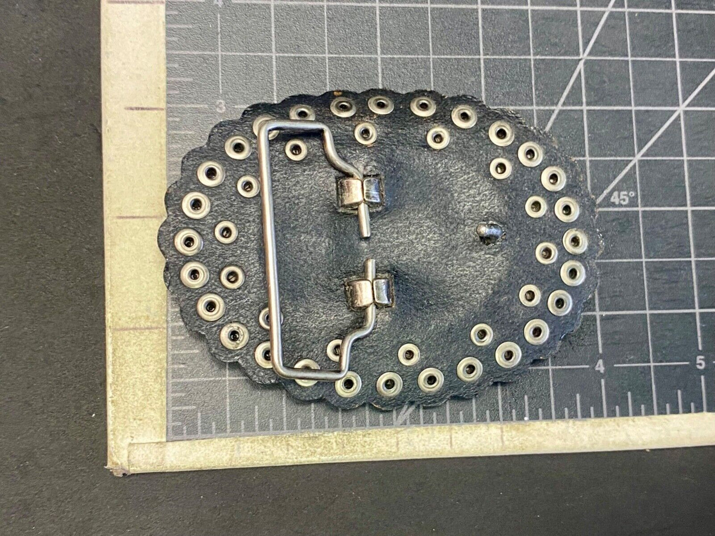 4" wide studded black leather oval belt buckle with flower swirl center