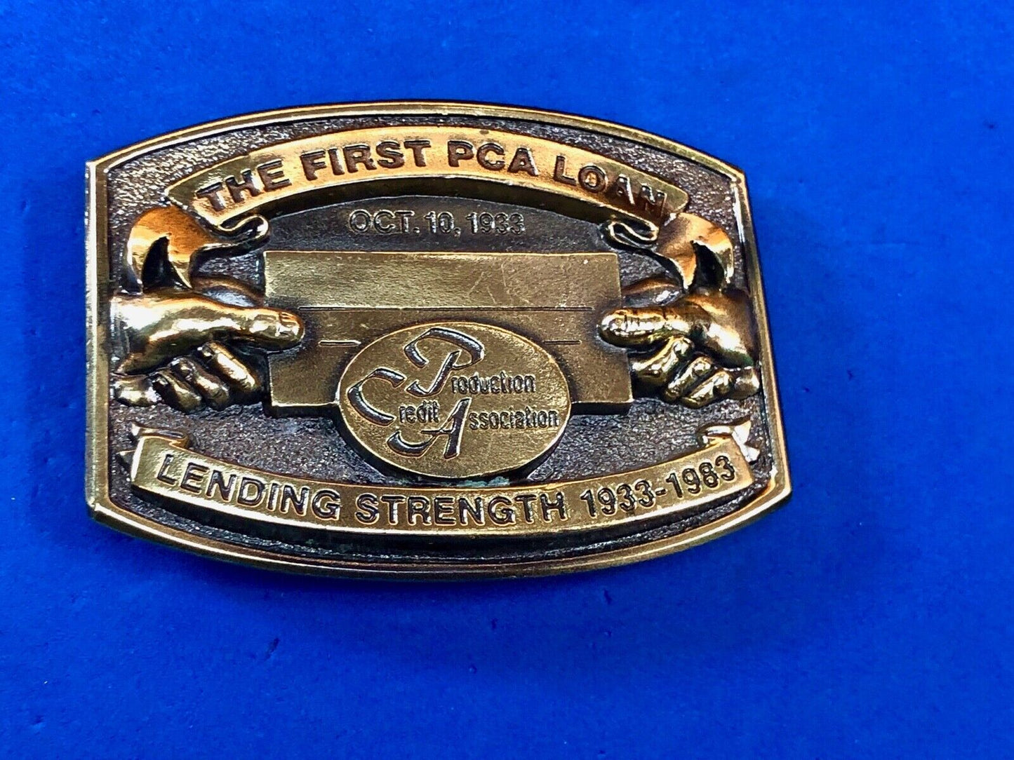 The first PCA loan belt buckle - Lending and strength production credit assn.