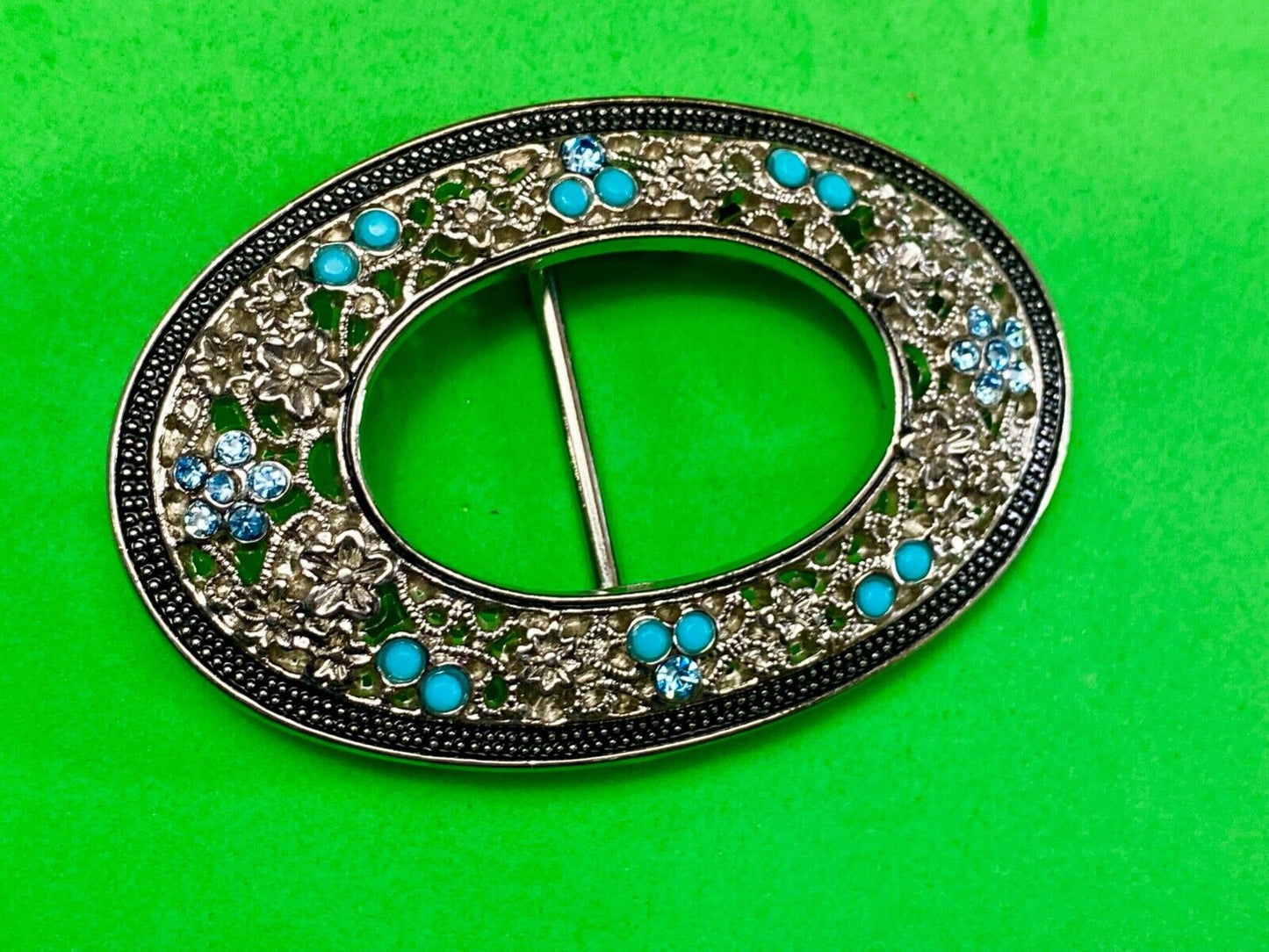 Unique blue rhinestone accented oval see though silver tone belt buckle