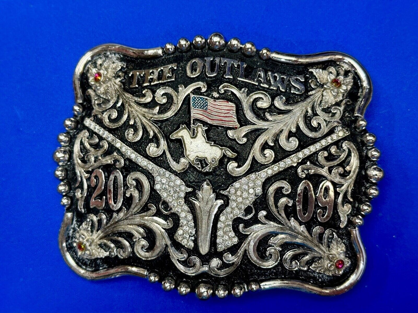 The Outlaws Rodeo Cowboy Trophy 2009 Flag Belt Buckle - Crossroads bucklesTexas