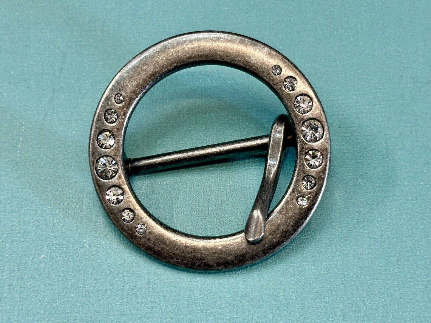 2" Round silver tone belt buckle with graduated rhinestone sized