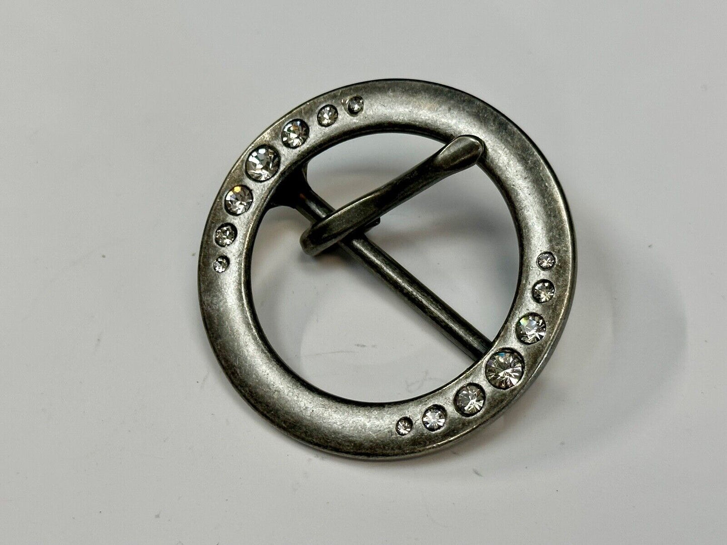 2" Round silver tone belt buckle with graduated rhinestone sized
