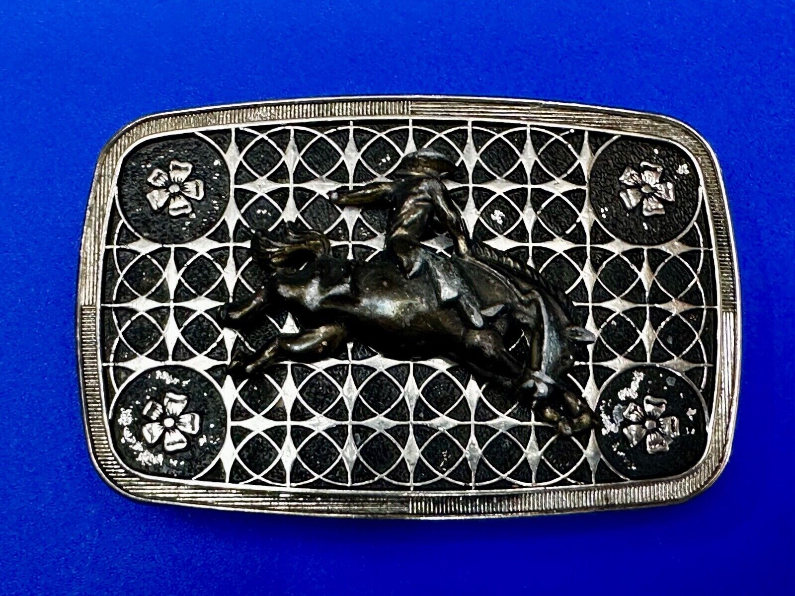 Vintage Cowboy on Saddle Bronc Western belt buckle with mesh pattern background