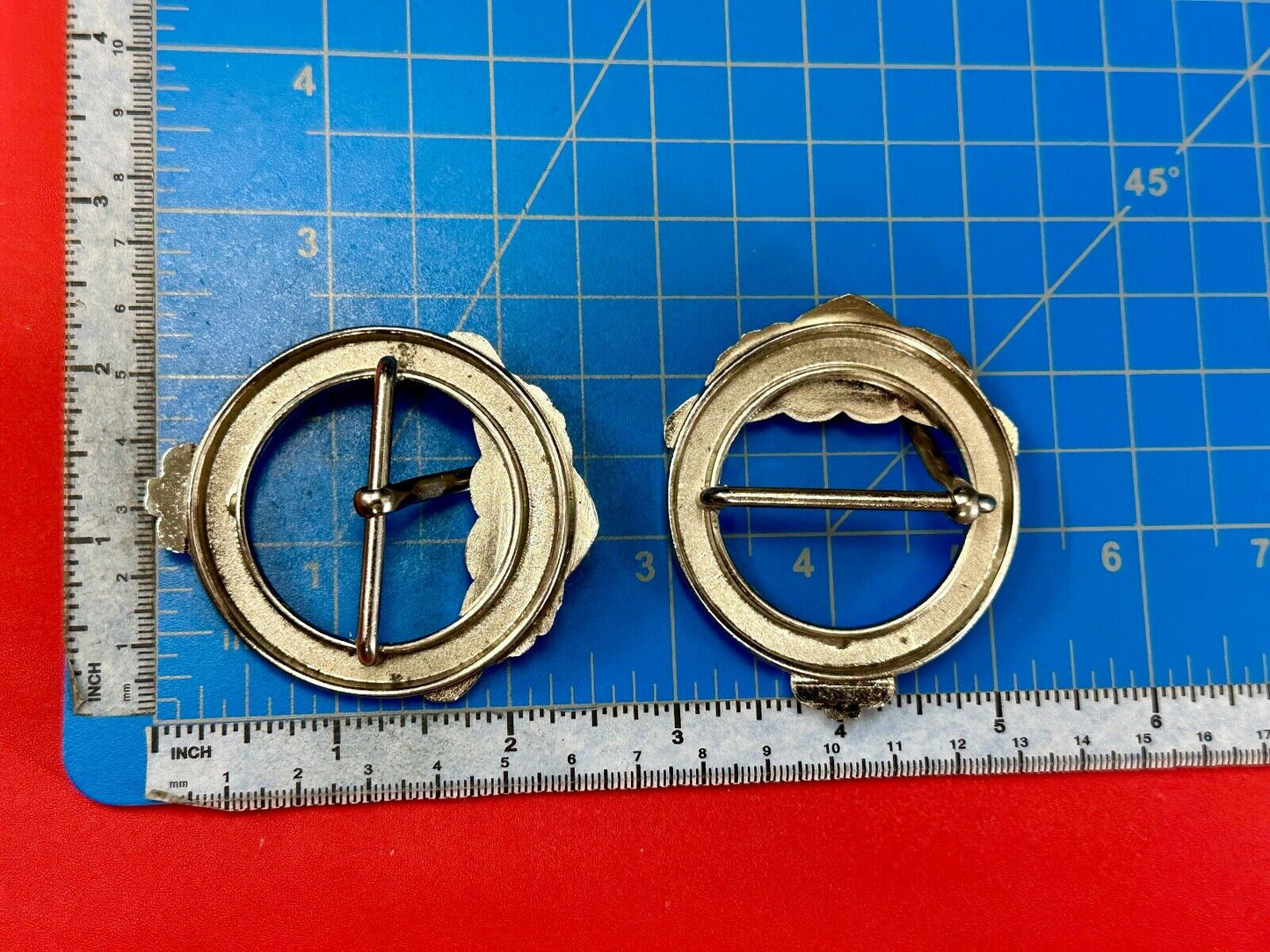 Two Kathy Van Zeeland signed silver tone round heart accented belt buckles