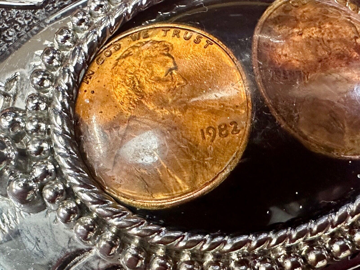 Two lucky pennies coins encased in cab style centerpiece of western belt buckle