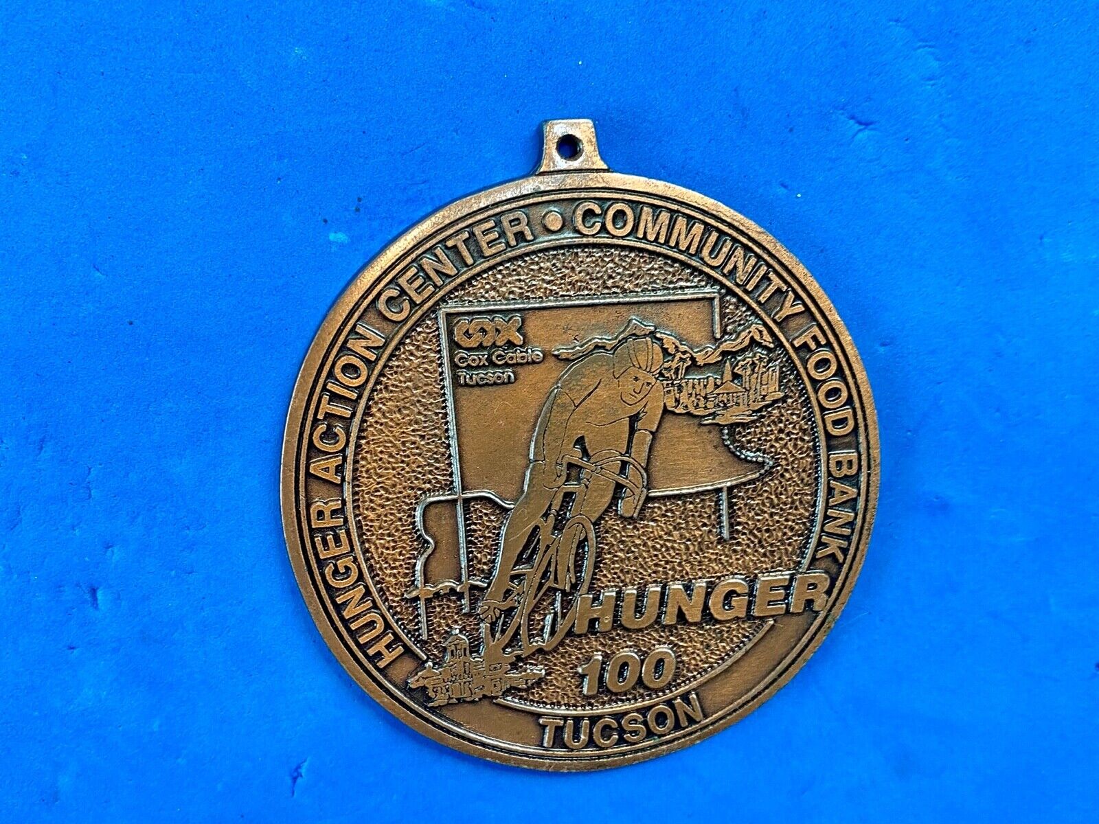award round medal from El Tour De Tucson HUNGER Race