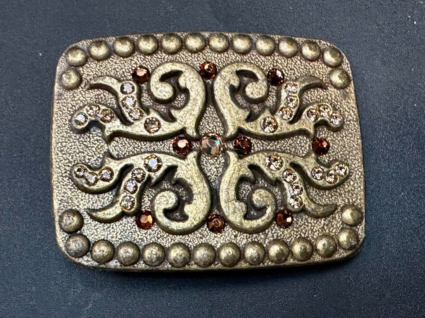 unique rhinestone accented swirl pattern on rounded rectangular belt buckle
