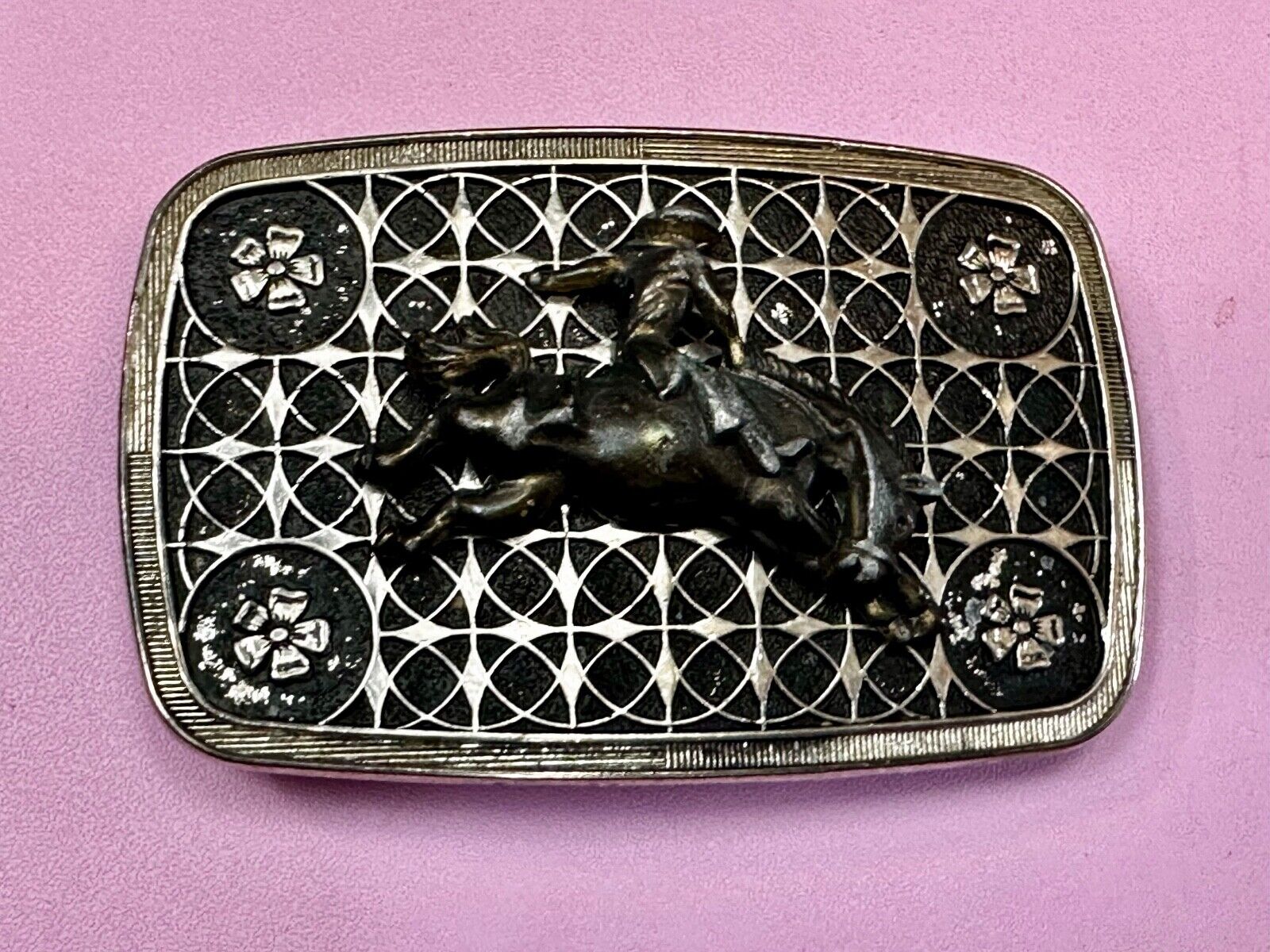 Vintage Cowboy on Saddle Bronc Western belt buckle with mesh pattern background