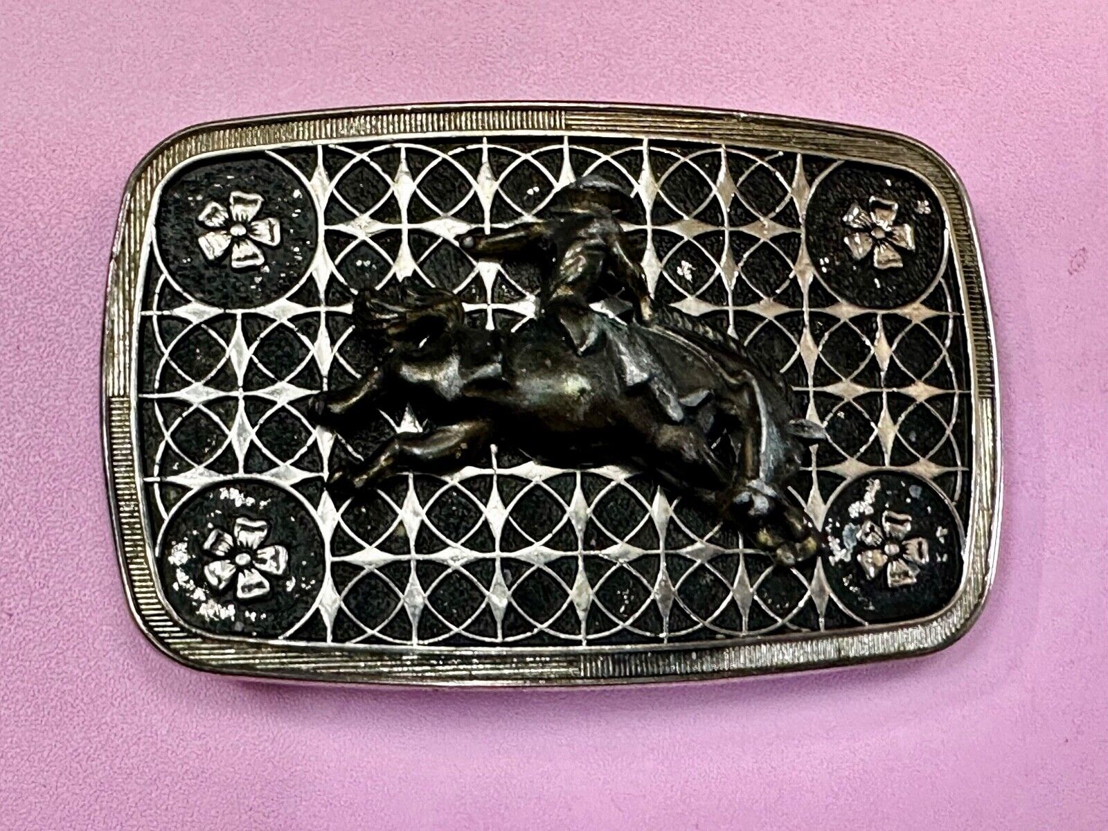 Vintage Cowboy on Saddle Bronc Western belt buckle with mesh pattern background