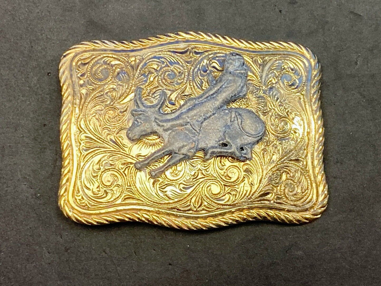 bull riding rodeo cowboy on beautiful gold color flower swirl belt buckle 