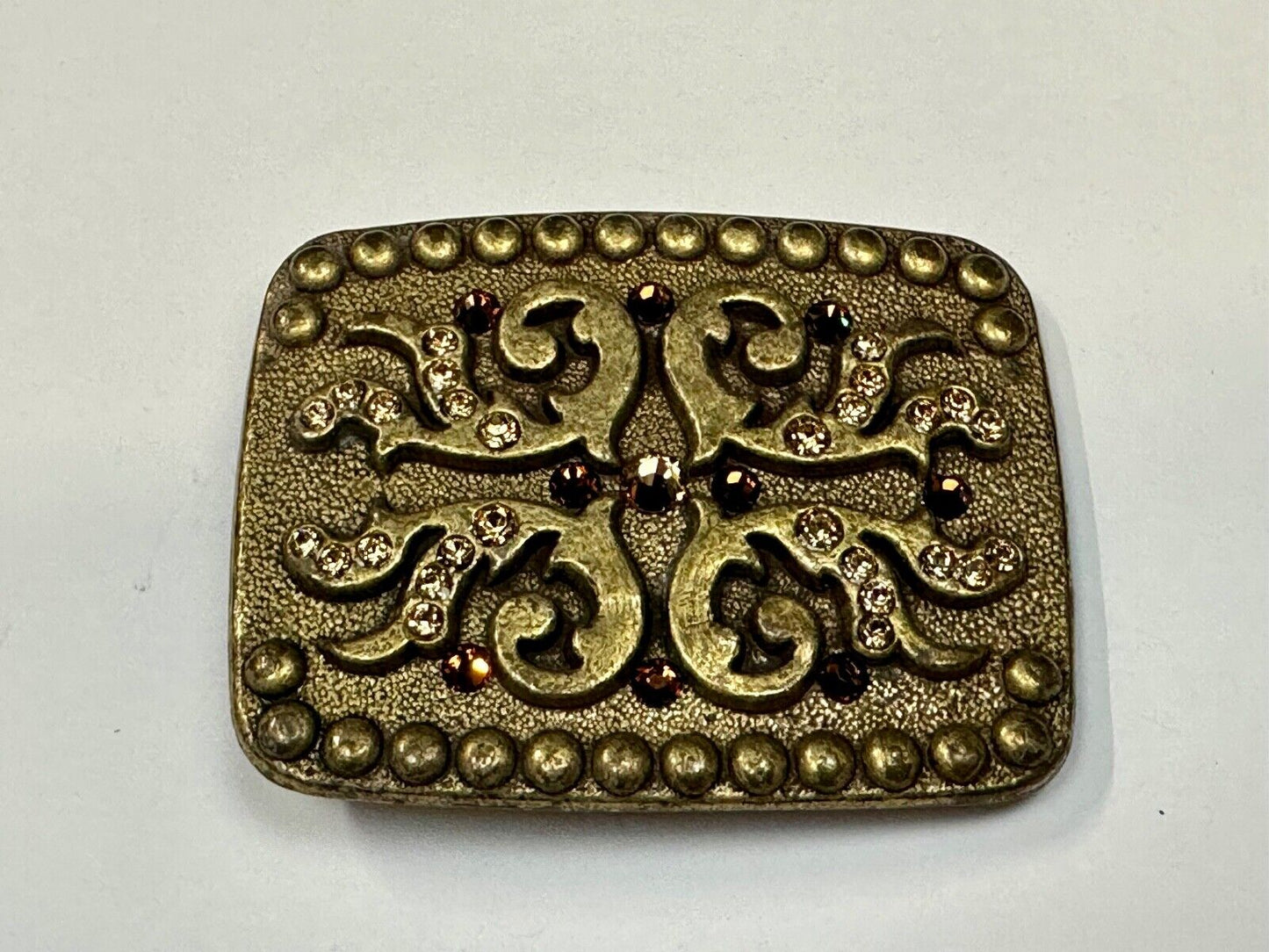 unique rhinestone accented swirl pattern on rounded rectangular belt buckle