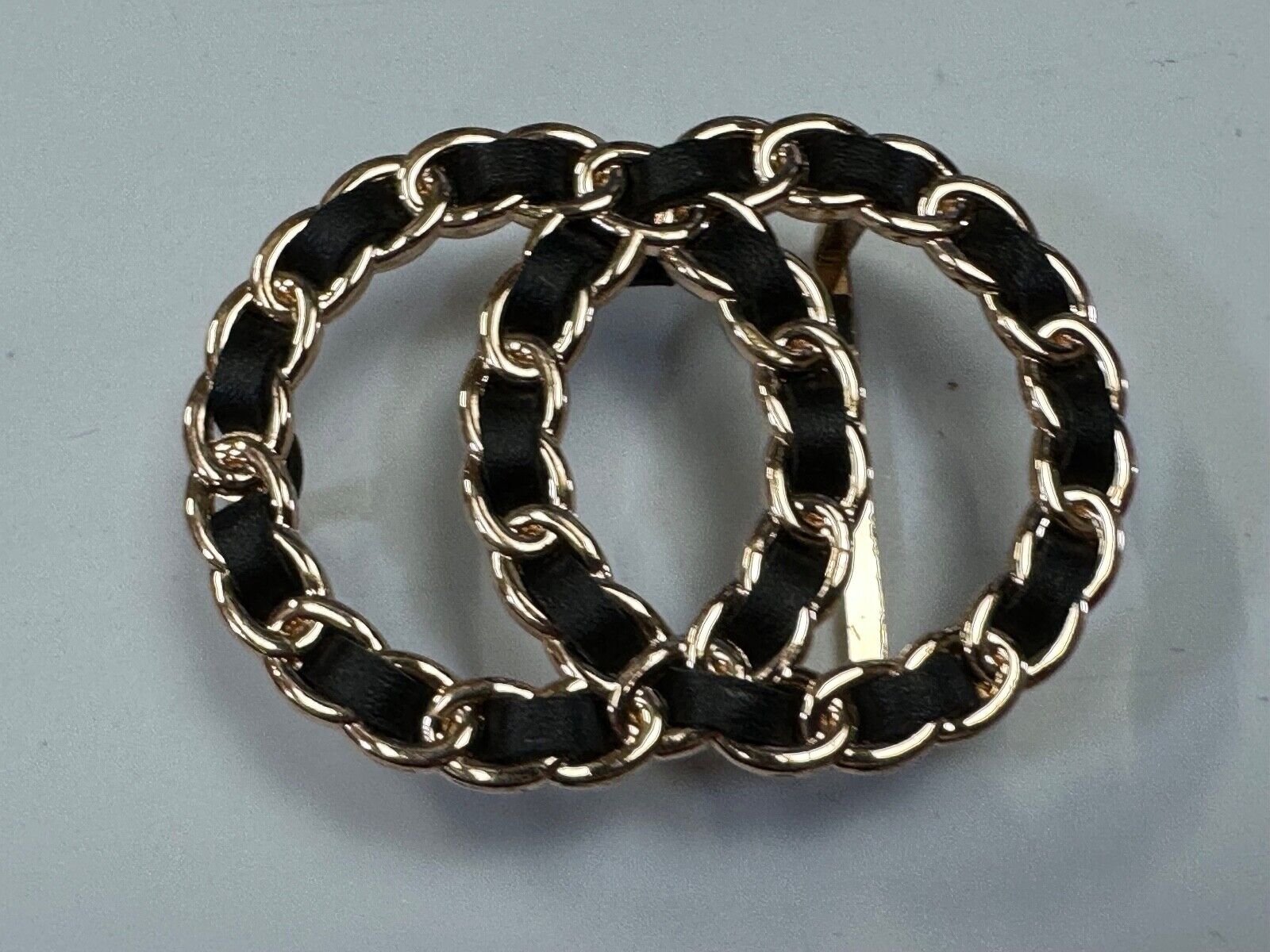 Two gold tone Overlapping Circle's with black ribbon through-out belt buckle