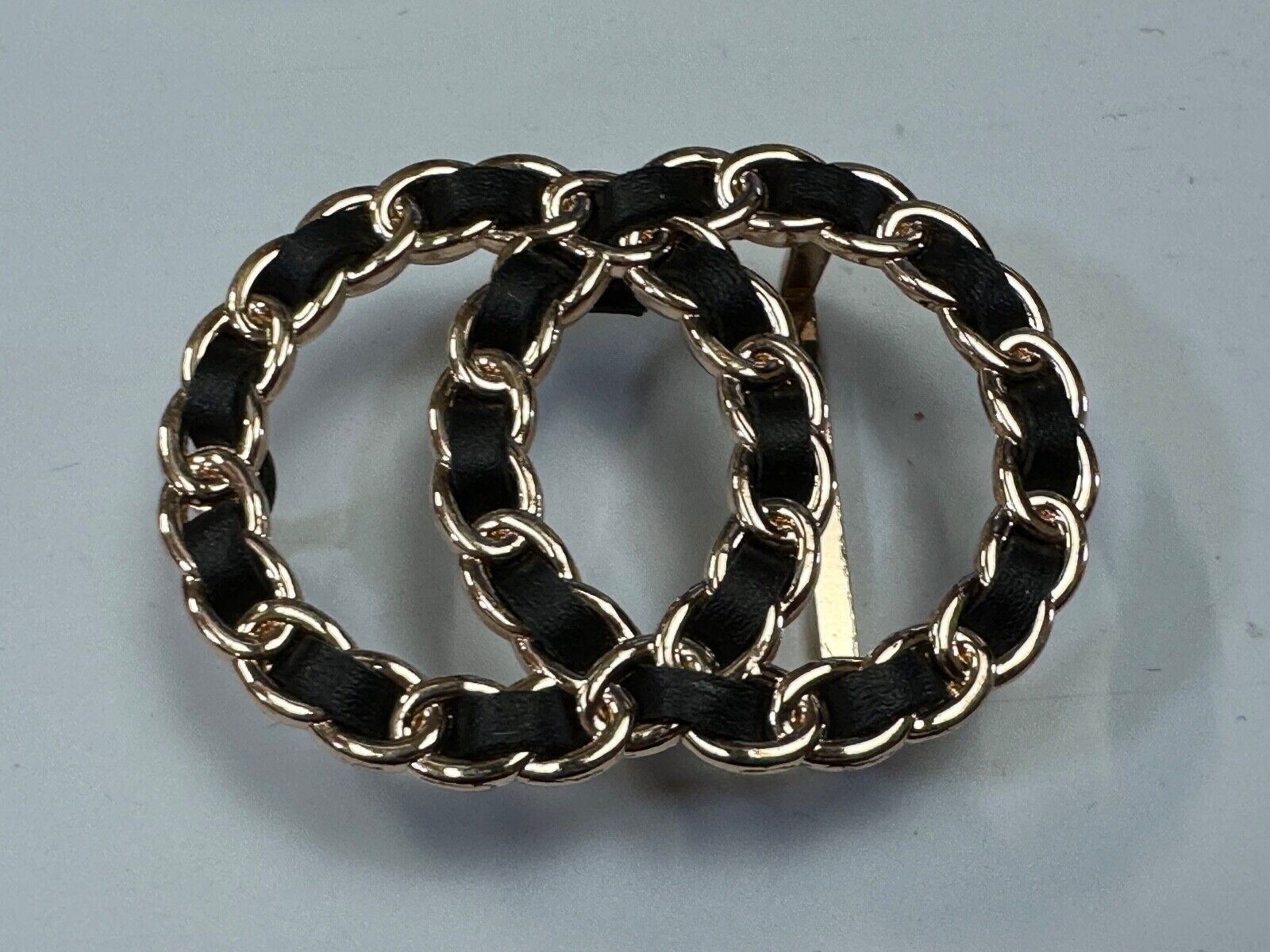 Two gold tone Overlapping Circle's with black ribbon through-out belt buckle