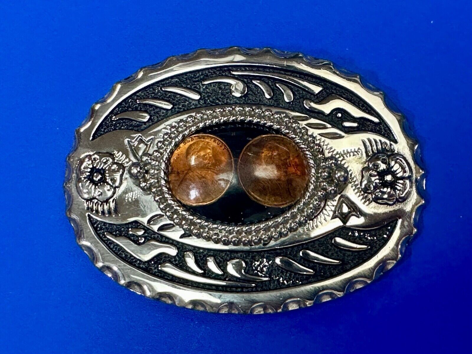 Two lucky pennies coins encased in cab style centerpiece of western belt buckle