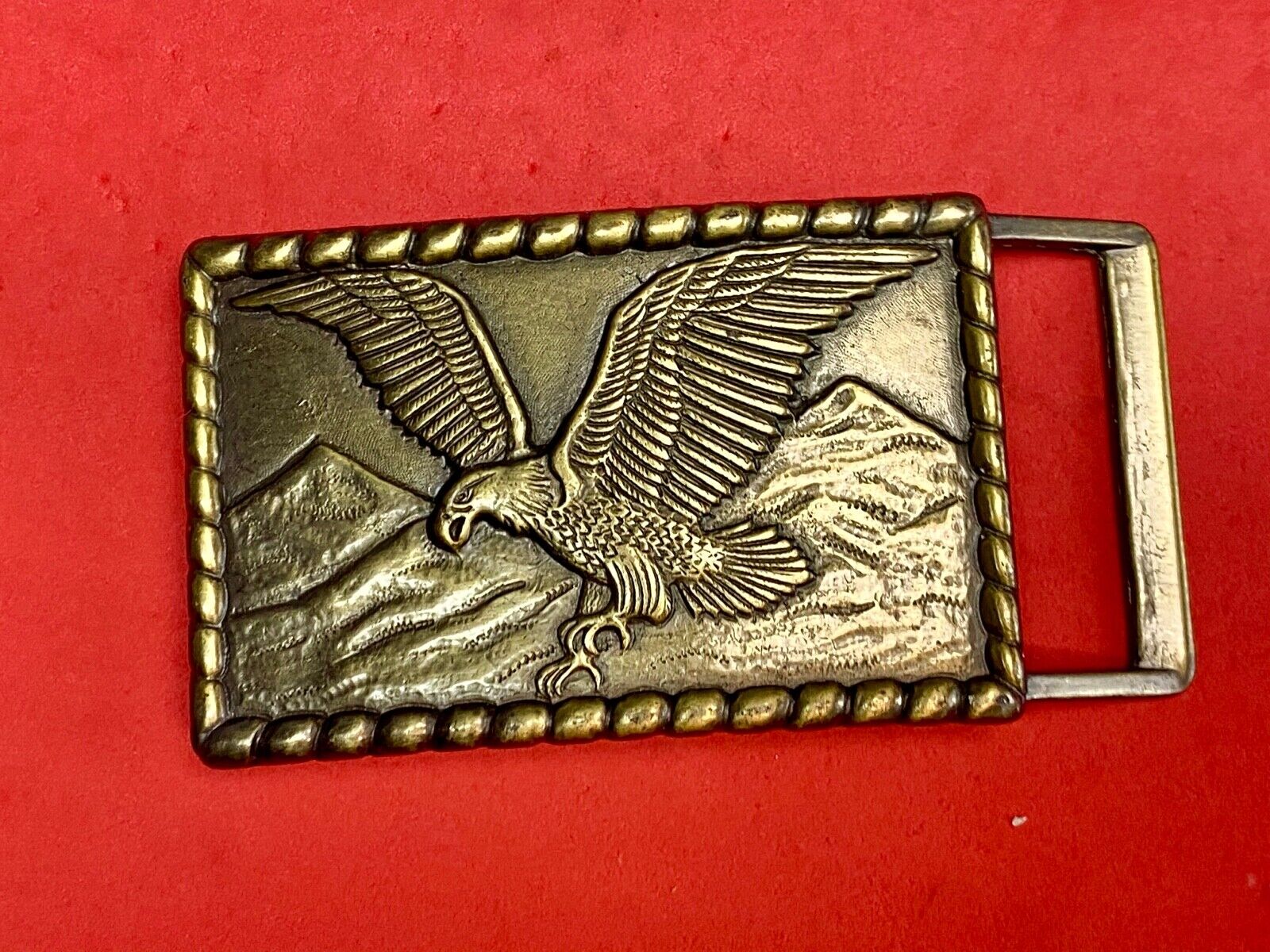 Vintage flying, hunting, fishing American eagle belt buckle with western boarder