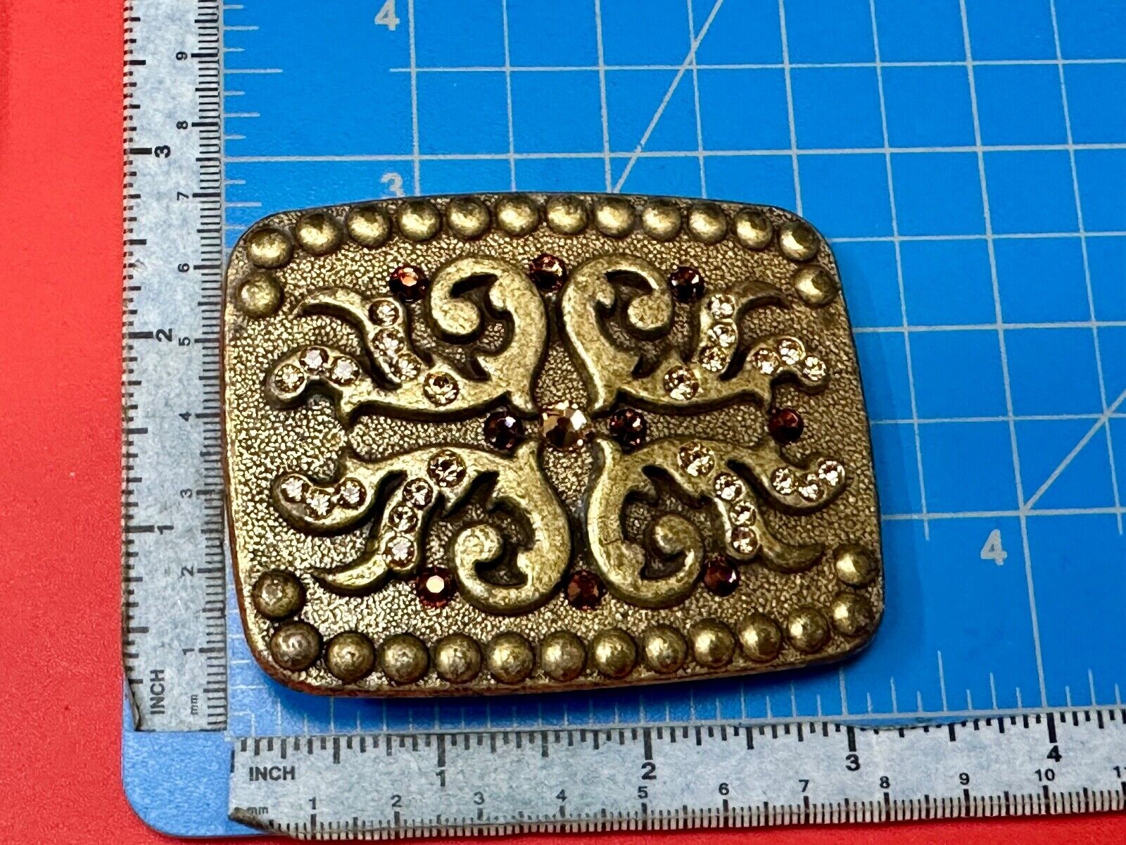 unique rhinestone accented swirl pattern on rounded rectangular belt buckle