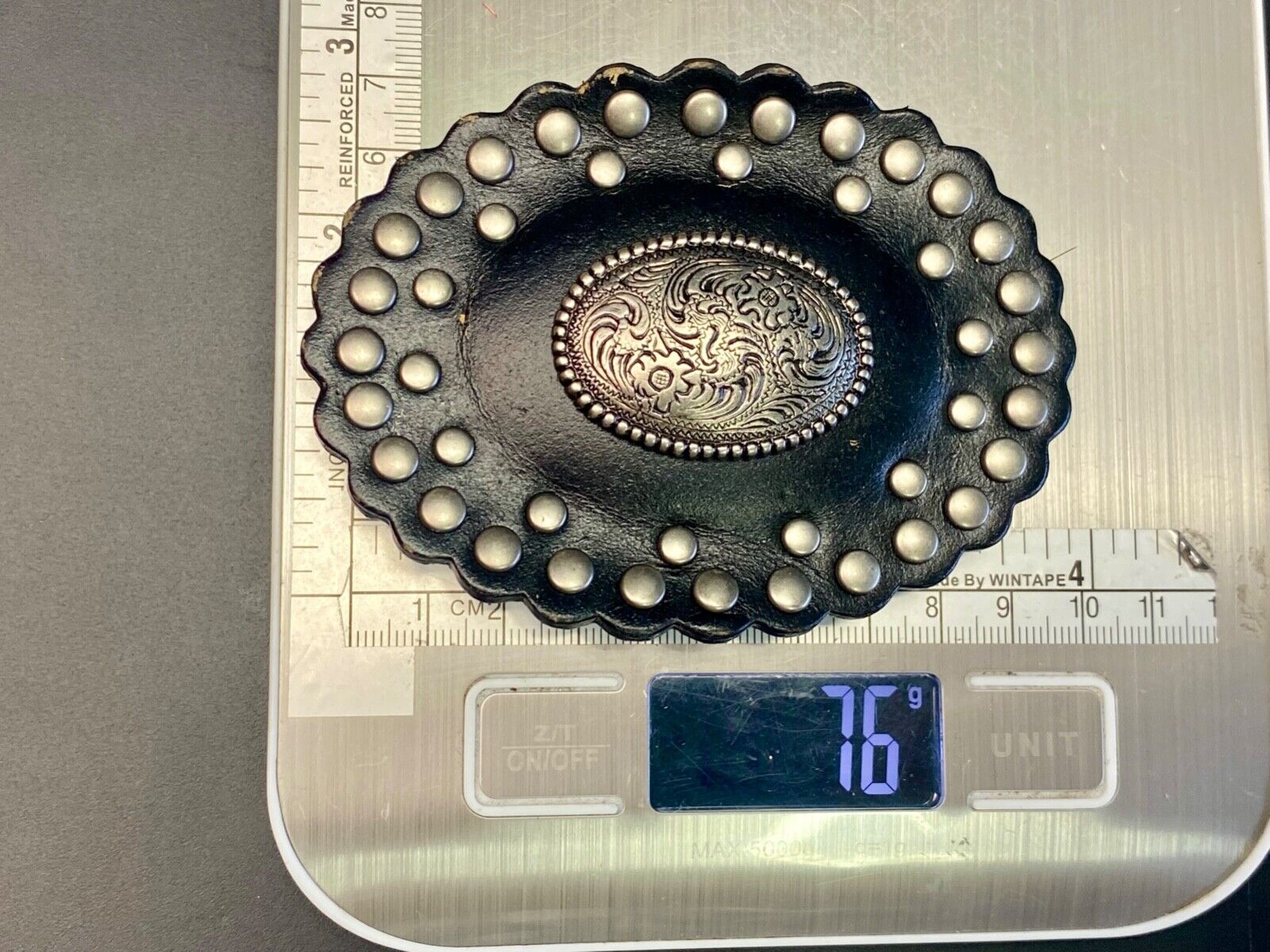 4" wide studded black leather oval belt buckle with flower swirl center