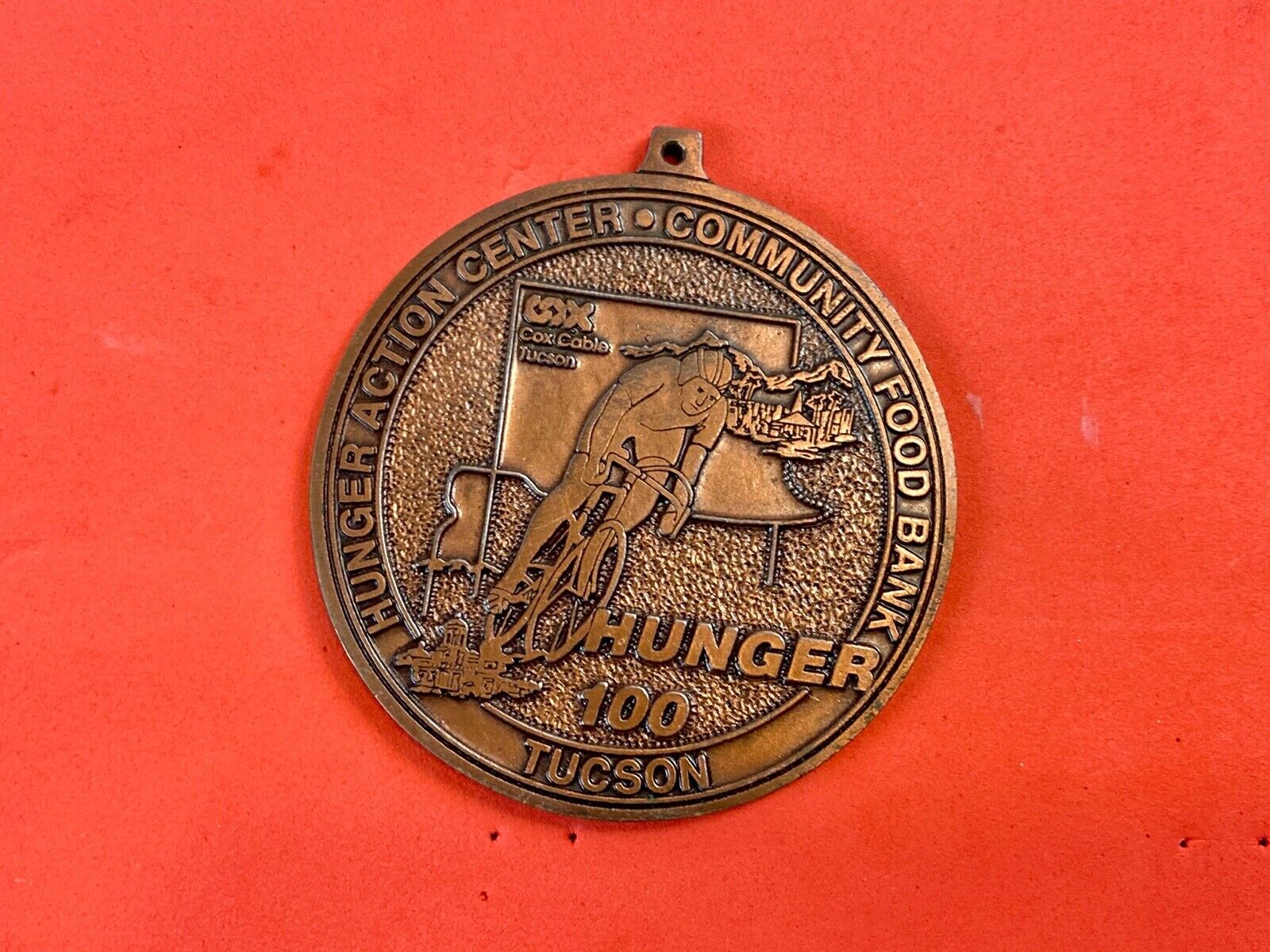 award round medal from El Tour De Tucson HUNGER Race