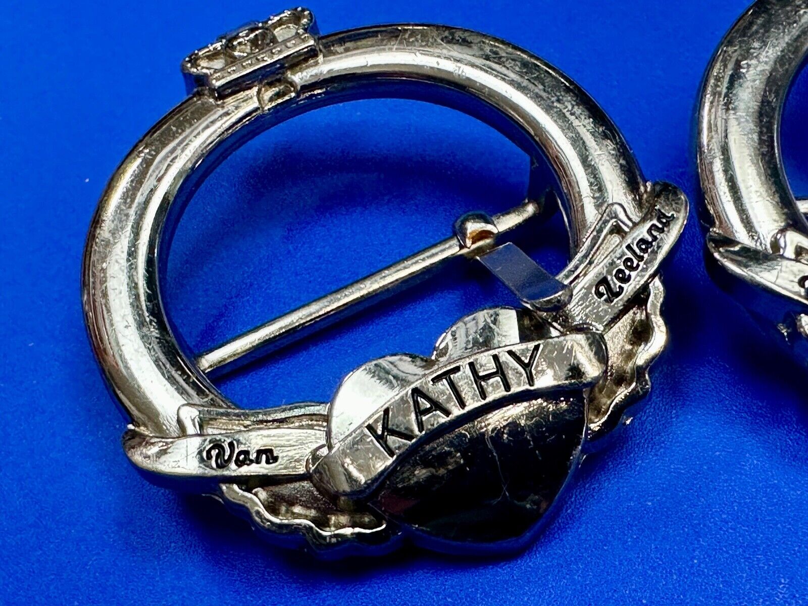 Two Kathy Van Zeeland signed silver tone round heart accented belt buckles