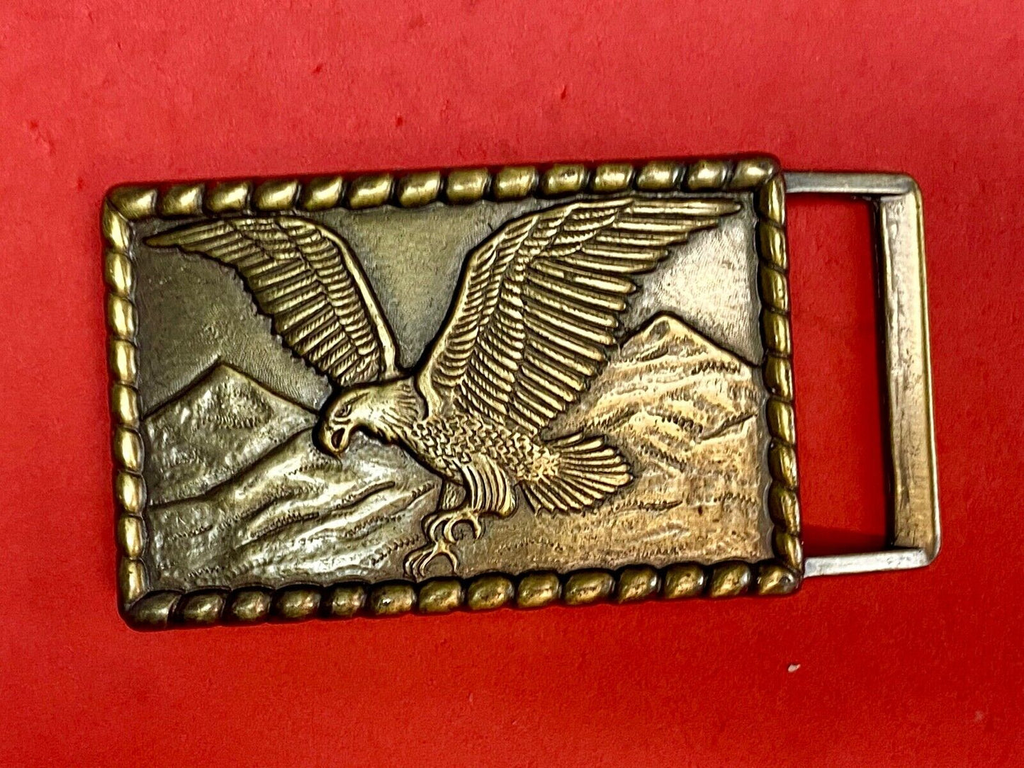 Vintage flying, hunting, fishing American eagle belt buckle with western boarder