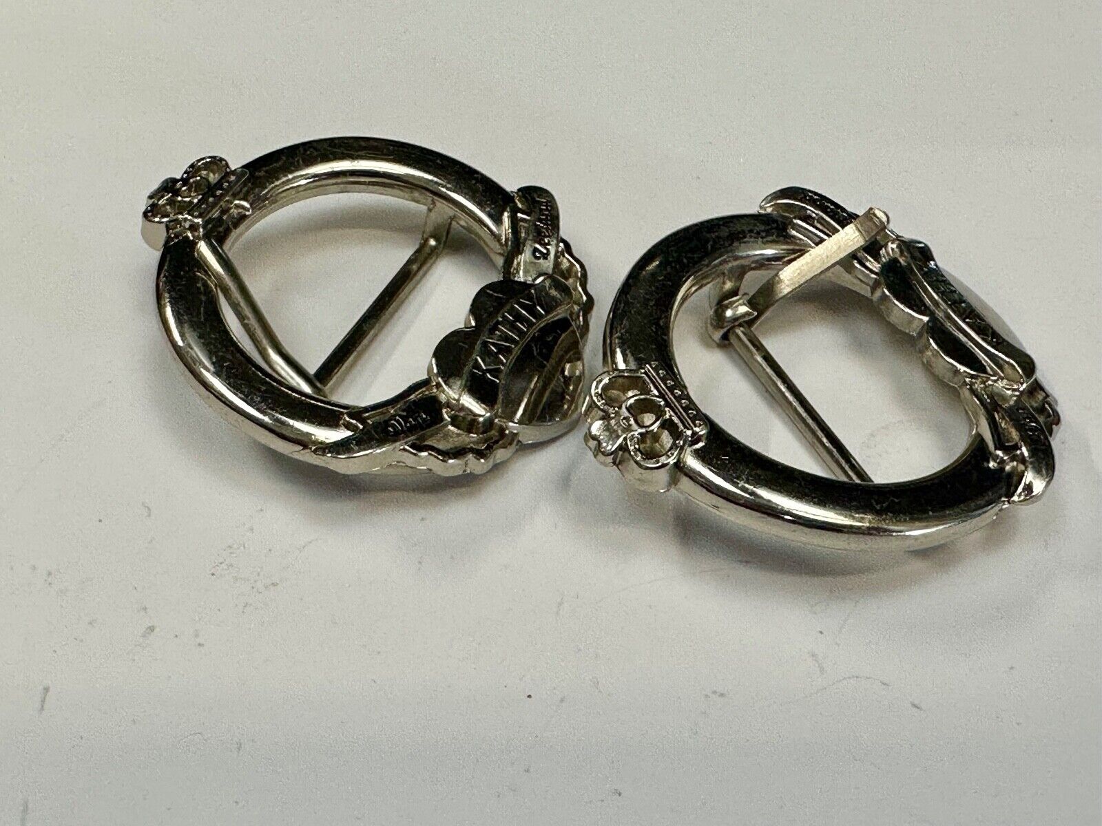 Two Kathy Van Zeeland signed silver tone round heart accented belt buckles