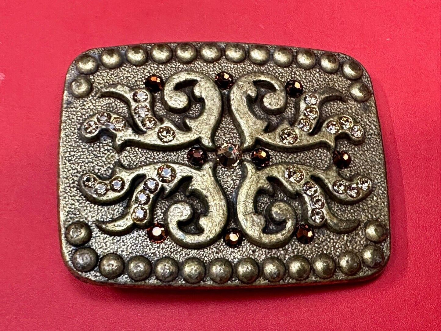 unique rhinestone accented swirl pattern on rounded rectangular belt buckle