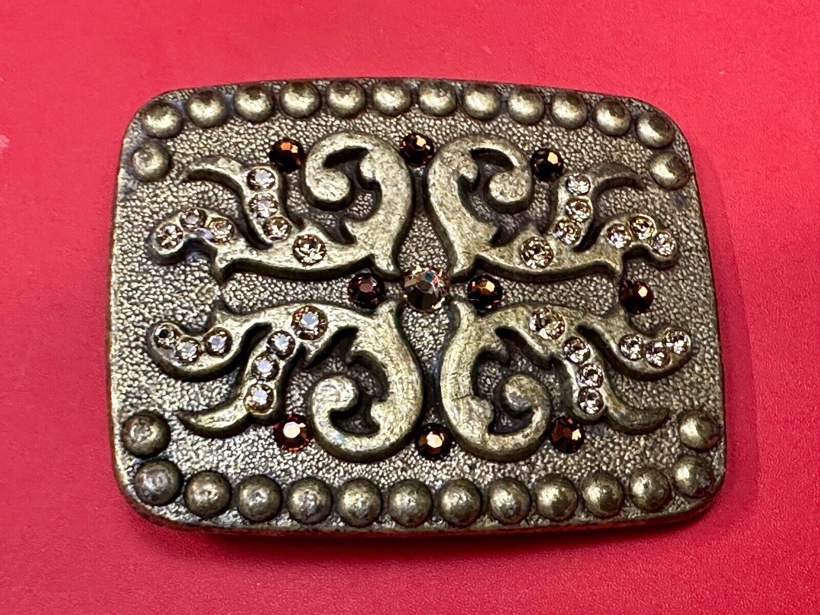 unique rhinestone accented swirl pattern on rounded rectangular belt buckle