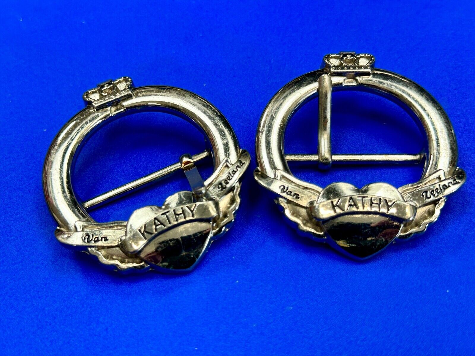 Two Kathy Van Zeeland signed silver tone round heart accented belt buckles