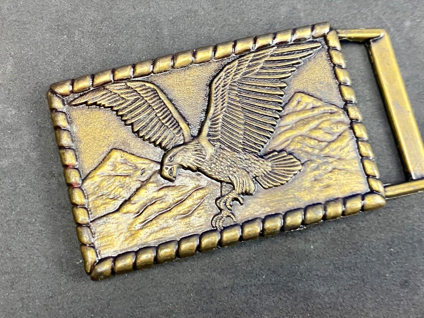 Vintage flying, hunting, fishing American eagle belt buckle with western boarder