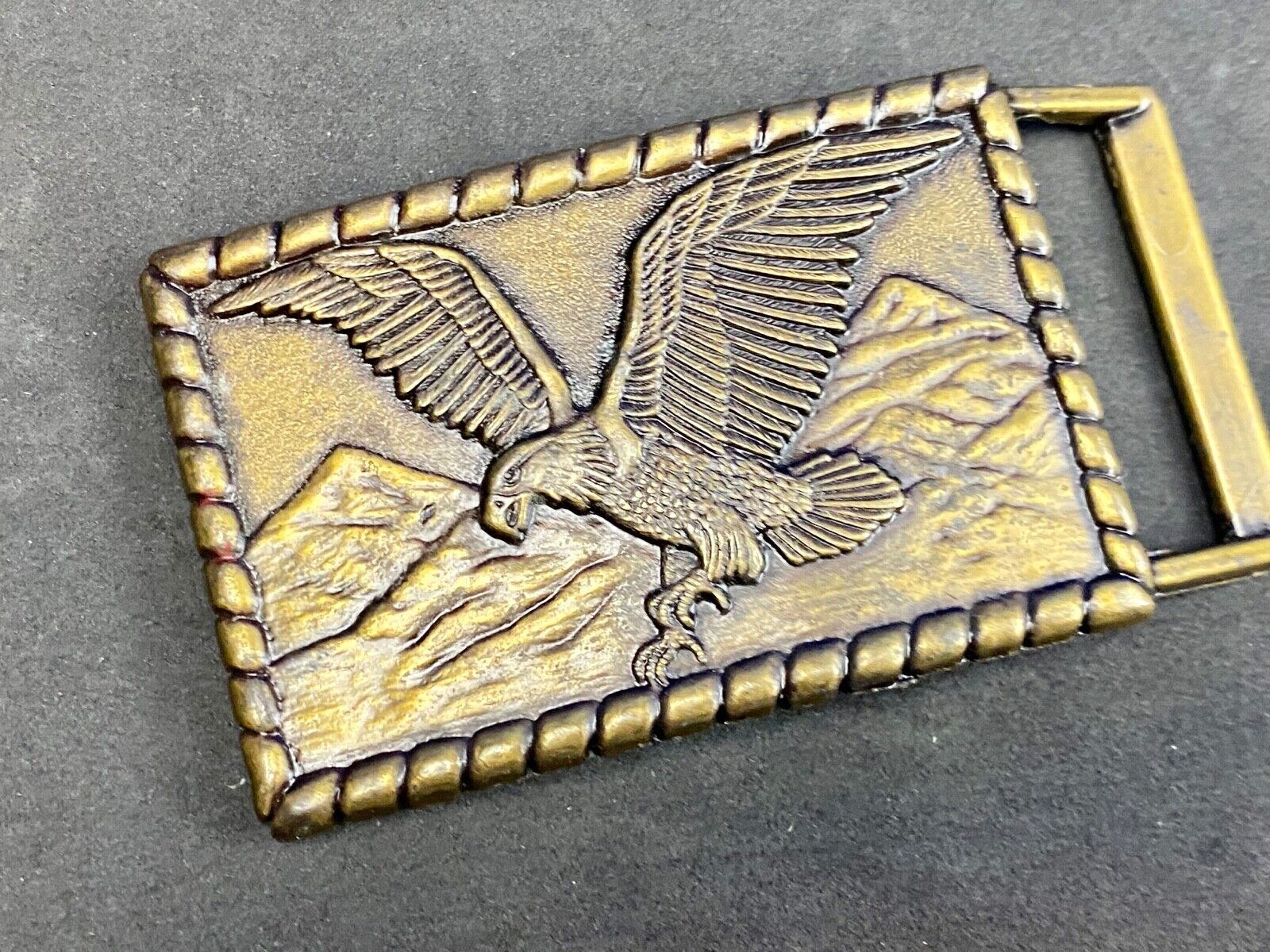Vintage flying, hunting, fishing American eagle belt buckle with western boarder
