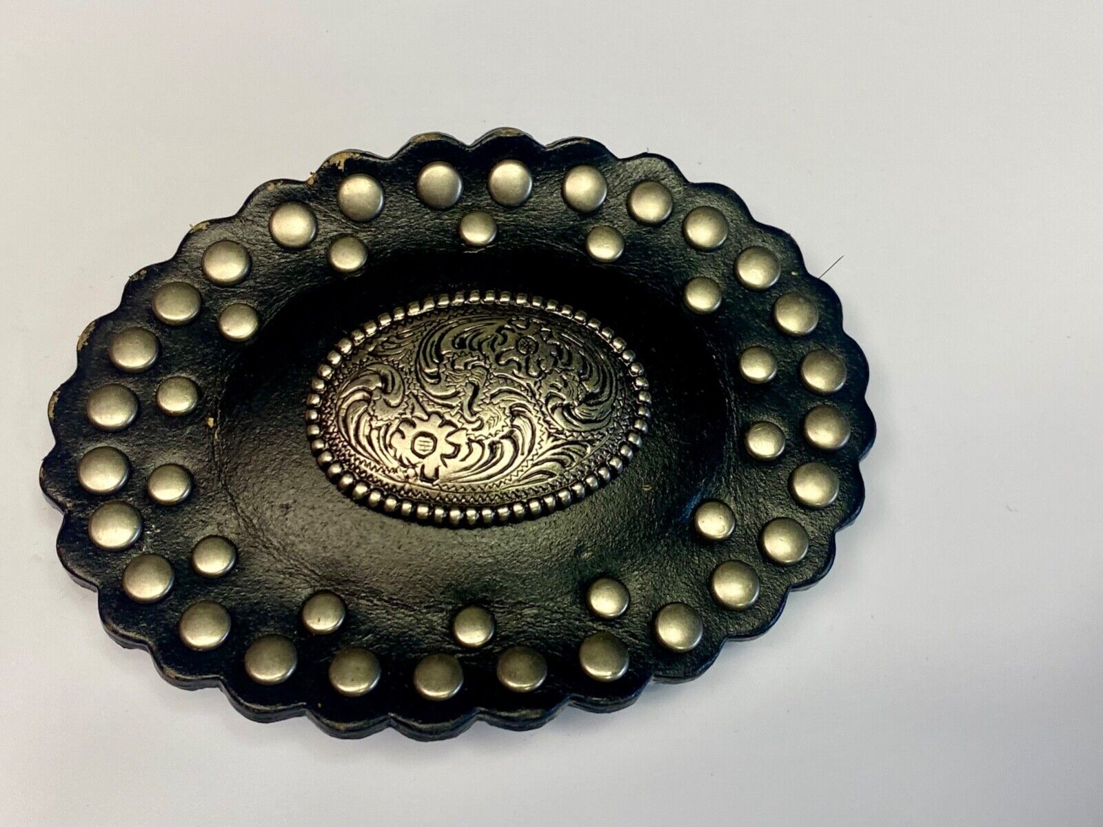 4" wide studded black leather oval belt buckle with flower swirl center