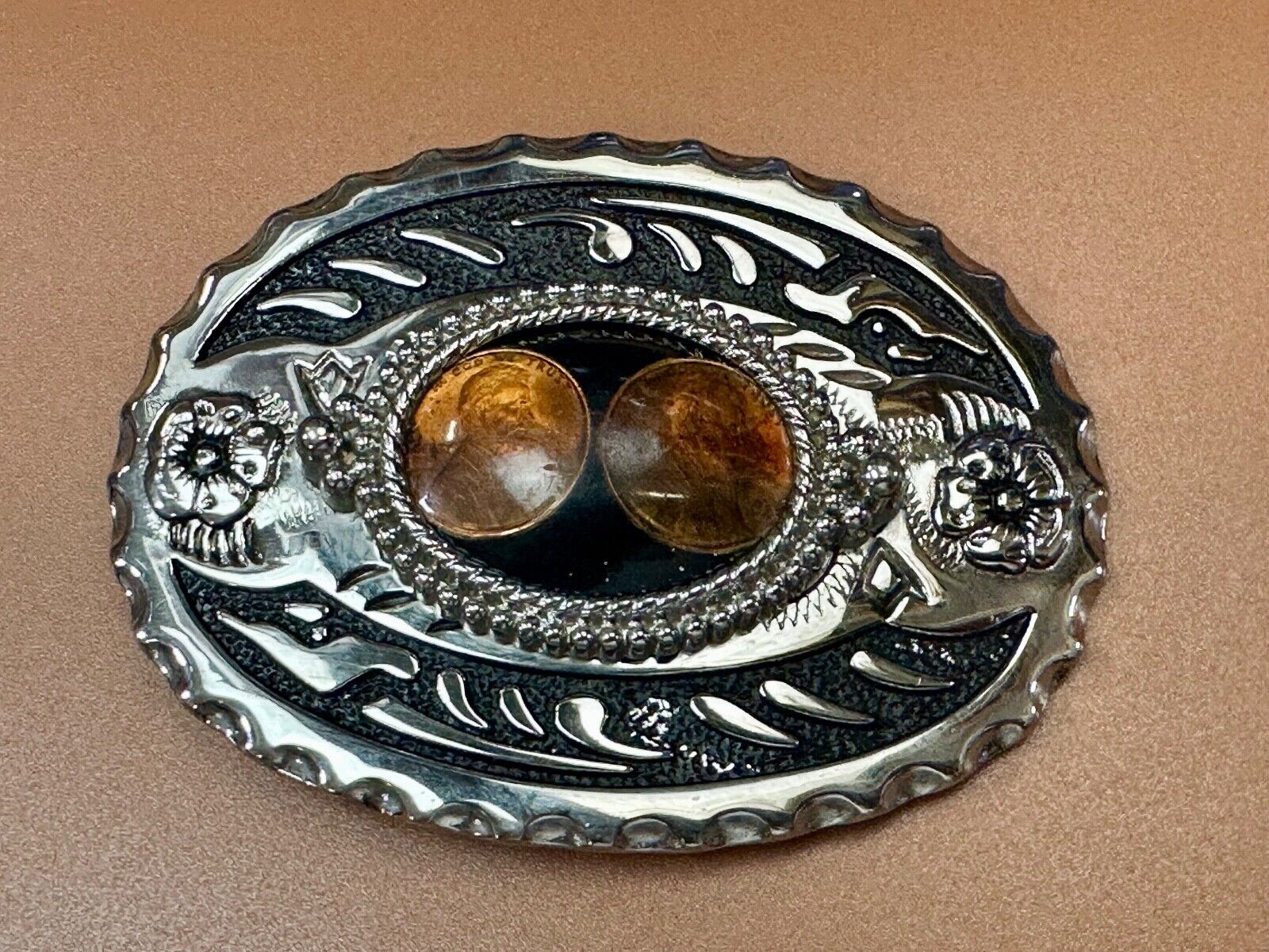 Two lucky pennies coins encased in cab style centerpiece of western belt buckle